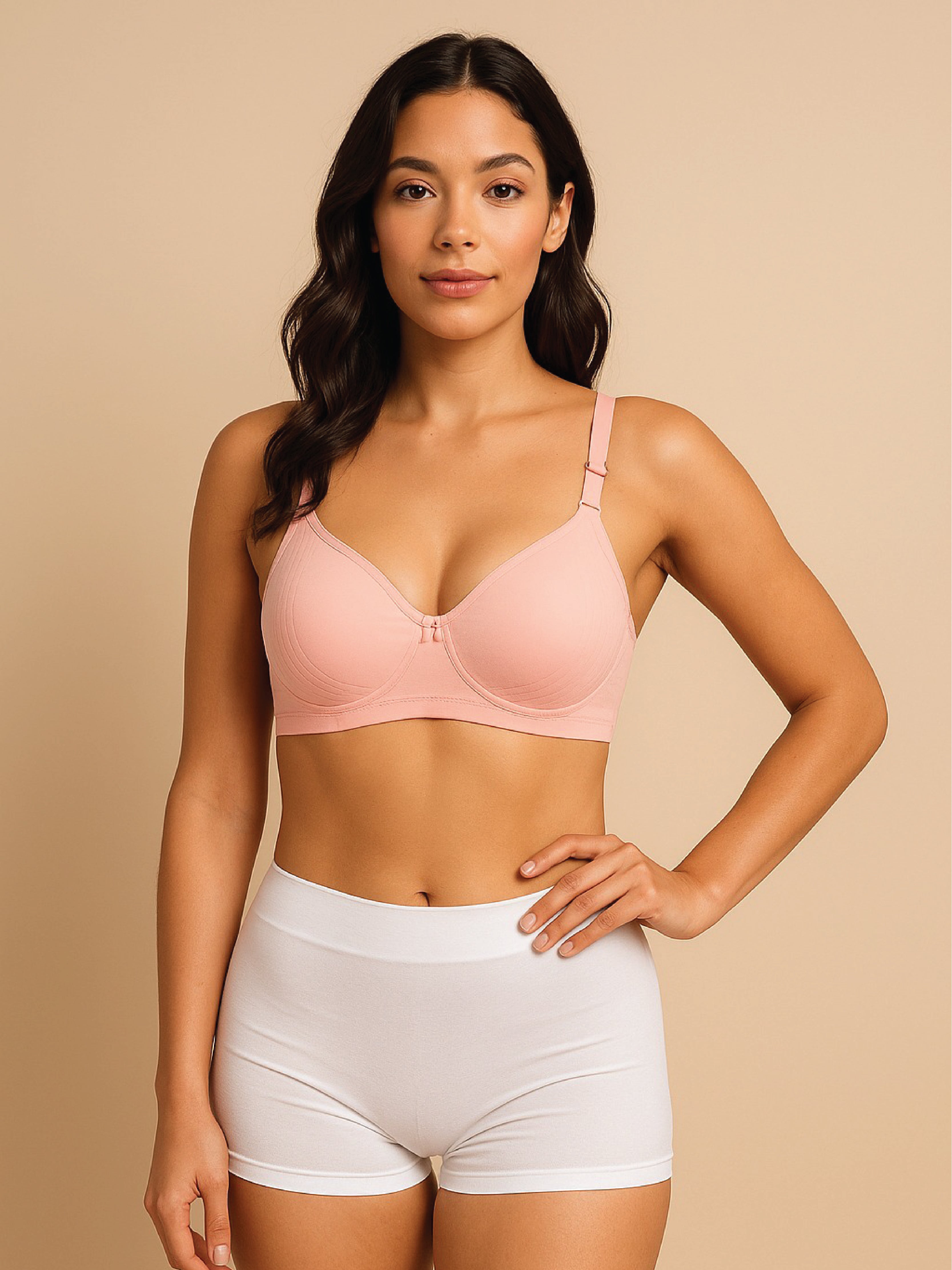Woman wearing a pink bra and white shorts against a beige background